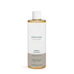 Klare Flasche Karmameju PROTECT body wash mit bernsteinfarbenem Duschgel und weißem Deckel